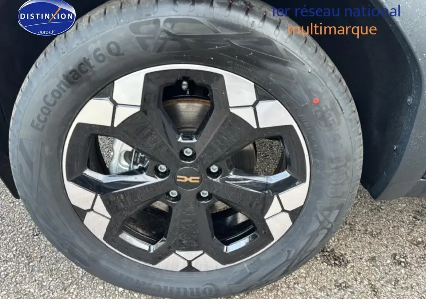 Gros plan sur la jante 18 pouces bicolore noire et argent du Dacia Bigster vert cèdre, avec pneu Continental EcoContact 6Q.