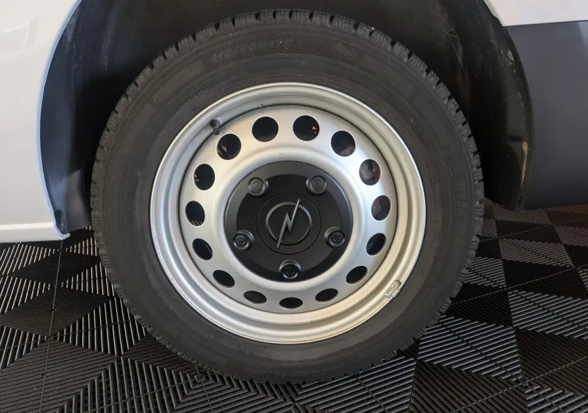 Gros plan sur la roue arrière droite avec jante tôle 17 pouces grise du fourgon blanc Opel Vivaro XL 2024.