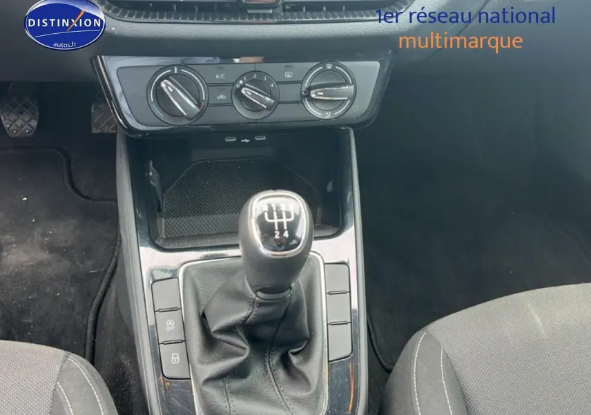 Vue intérieure centrée sur le levier de vitesse manuel et la console centrale de la Skoda Fabia bleue 2025.