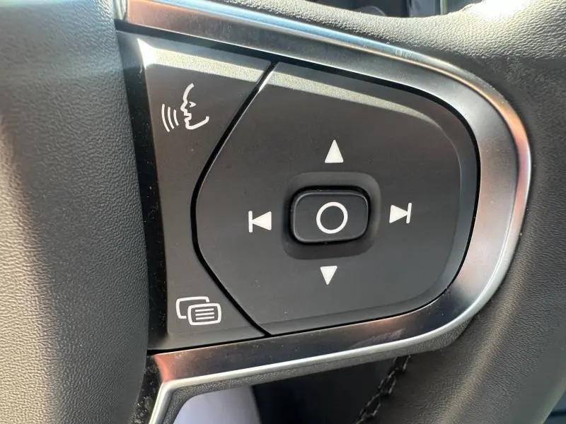 Boutons de commande vocale et navigation sur le volant noir du Volvo S60 gris Platinium 2024, finition B4 hybride.