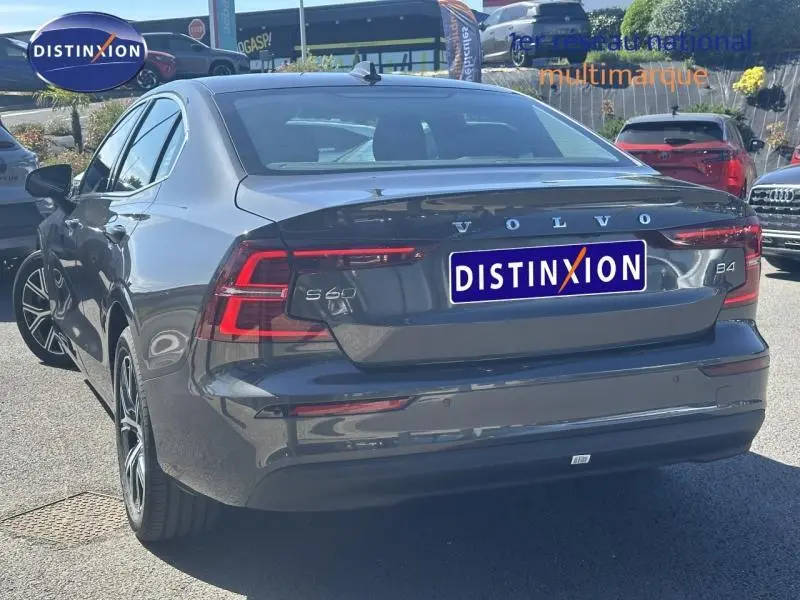 Vue 3/4 arrière droite d'une Volvo S60 B4 gris Platinium métallisé avec feux LED et jantes alliage.