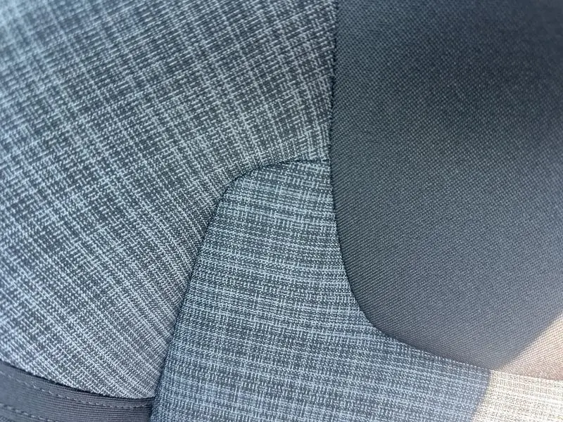 Détail du tissu gris à motifs croisés du siège avant du Volvo S60 B4 197ch 2024, vue rapprochée côté droit.