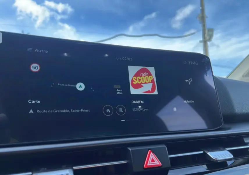 Écran tactile central affichant la navigation et la radio dans un Kia Sportage 1.6 T-GDI HEV 239 GT toit panoramique.
