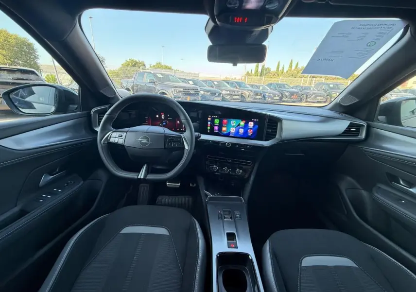 Vue intérieure avant de l’Opel Mokka électrique 2025, tableau de bord moderne avec écran tactile et volant noir.