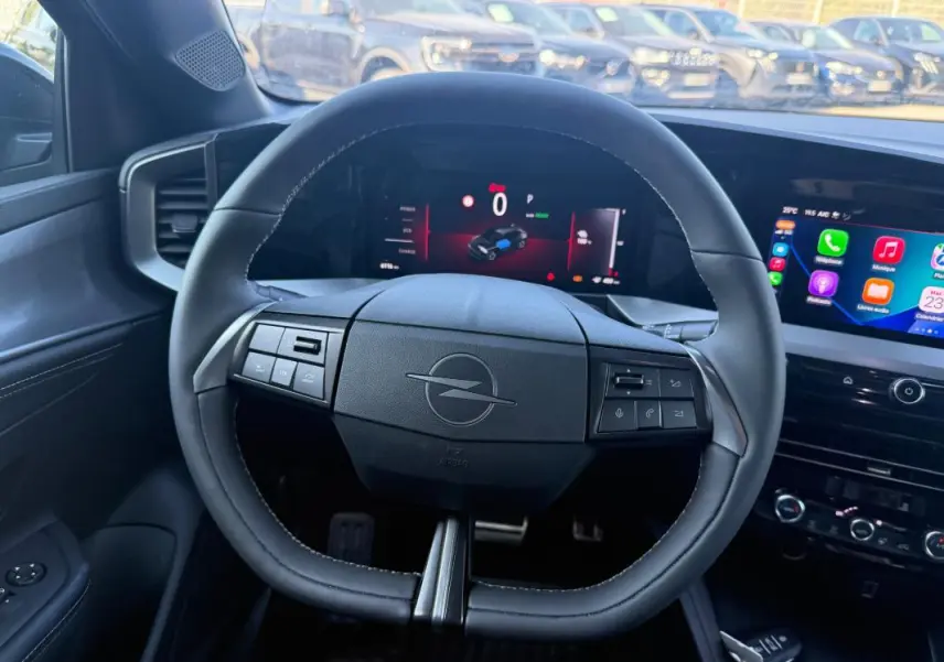 Vue intérieure centrée sur le volant noir de l'Opel Mokka électrique 2025 avec tableau de bord numérique et écran tactile.