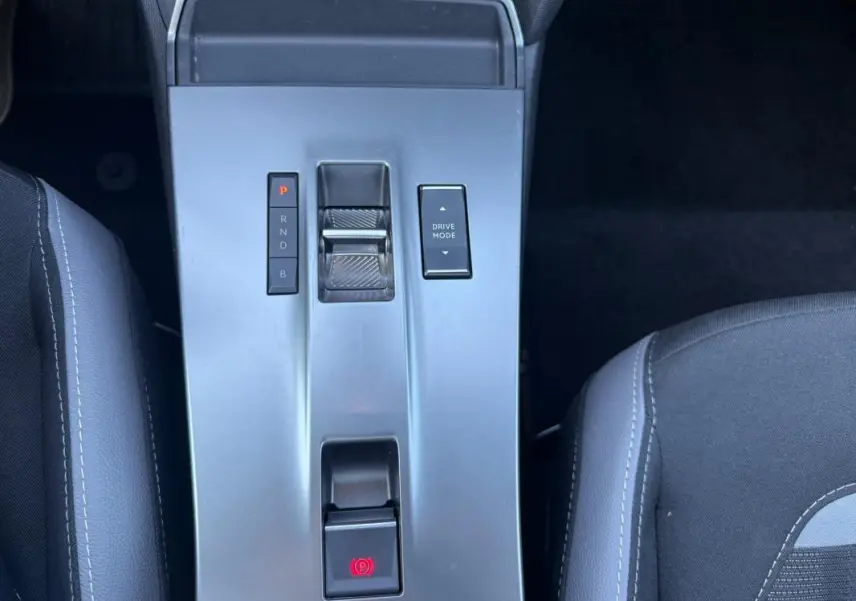Vue plongeante sur la console centrale grise de l’Opel Mokka électrique 2025 avec commandes de boîte auto et mode de conduite.