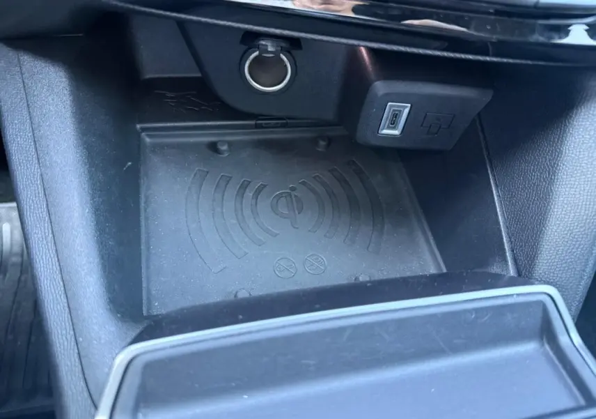 Gros plan sur le compartiment de recharge sans fil et port USB dans l’habitacle noir de l’Opel Mokka électrique 2025.