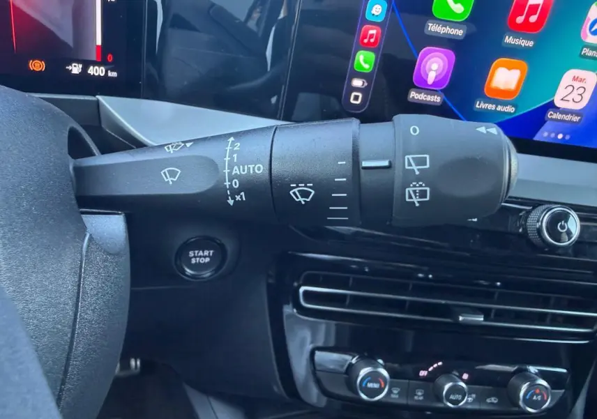 Gros plan sur la commande d’essuie-glace à gauche du volant dans l’habitacle noir de l’Opel Mokka électrique 2025.