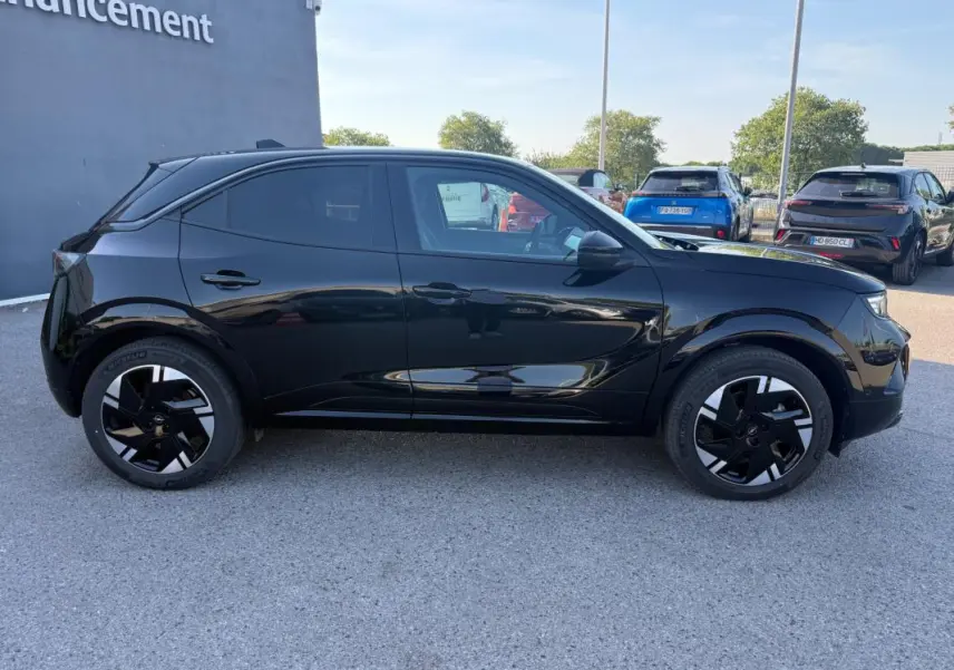 Profil côté gauche de l'Opel Mokka électrique noir 2025 avec jantes alliage 17 pouces et vitres surteintées.