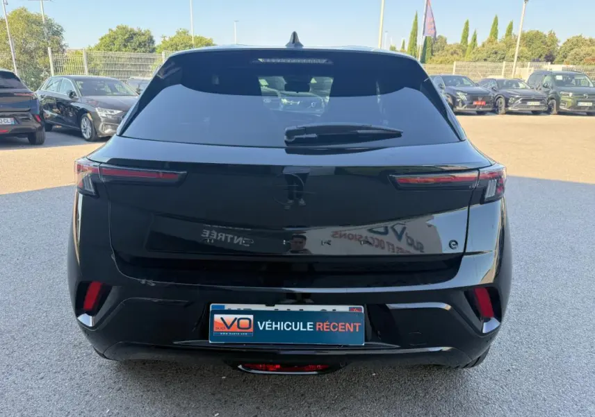 Vue arrière d’un Opel Mokka électrique noir 2025 avec feux arrière fins et vitres surteintées.