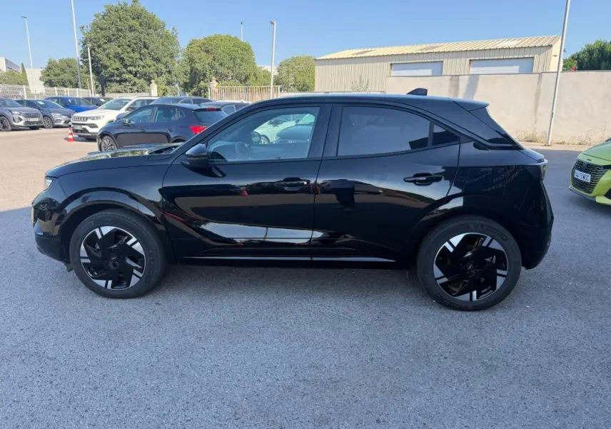 Opel Mokka électrique noir vue de profil côté gauche, avec jantes alliage 17 pouces et vitres surteintées.