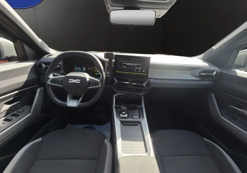 Vue intérieure avant du tableau de bord et volant noir du Dacia Bigster Journey Hybrid 2025 avec écran tactile central.