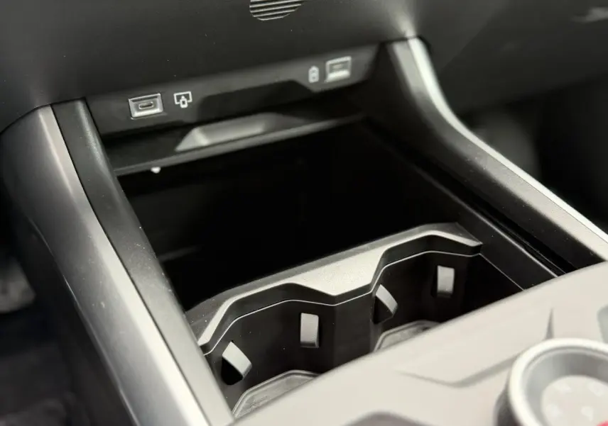 Gros plan sur la console centrale noire du Jeep Compass 2026, montrant les porte-gobelets et ports USB.