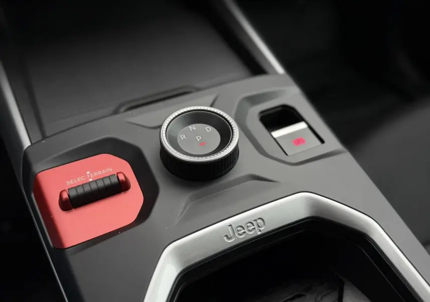 Gros plan sur la console centrale du Jeep Compass 2026, avec sélecteur de vitesse rotatif et bouton rouge Selec-Terrain.