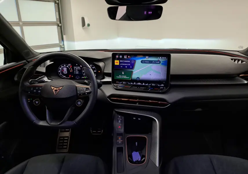 Vue intérieure du tableau de bord du CUPRA TERRAMAR 2025, avec écran tactile central et volant multifonction noir.