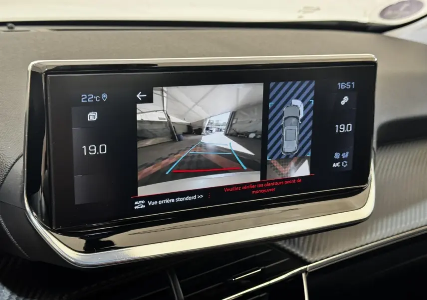 Écran tactile intérieur du Peugeot 2008 blanc, affichant la caméra de recul et l'aide au stationnement arrière.