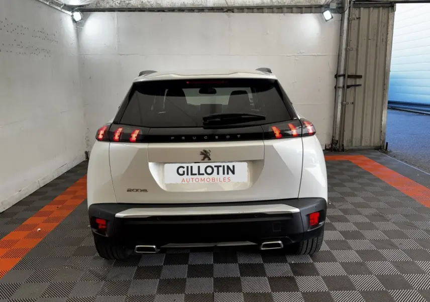 Vue arrière d’un Peugeot 2008 blanc avec feux LED caractéristiques et double sortie d’échappement rectangulaire.