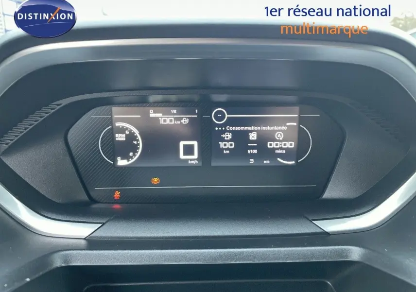 Tableau de bord numérique du Peugeot Partner 2025, affichage de la consommation instantanée et compteur de vitesse à 0 km/h.