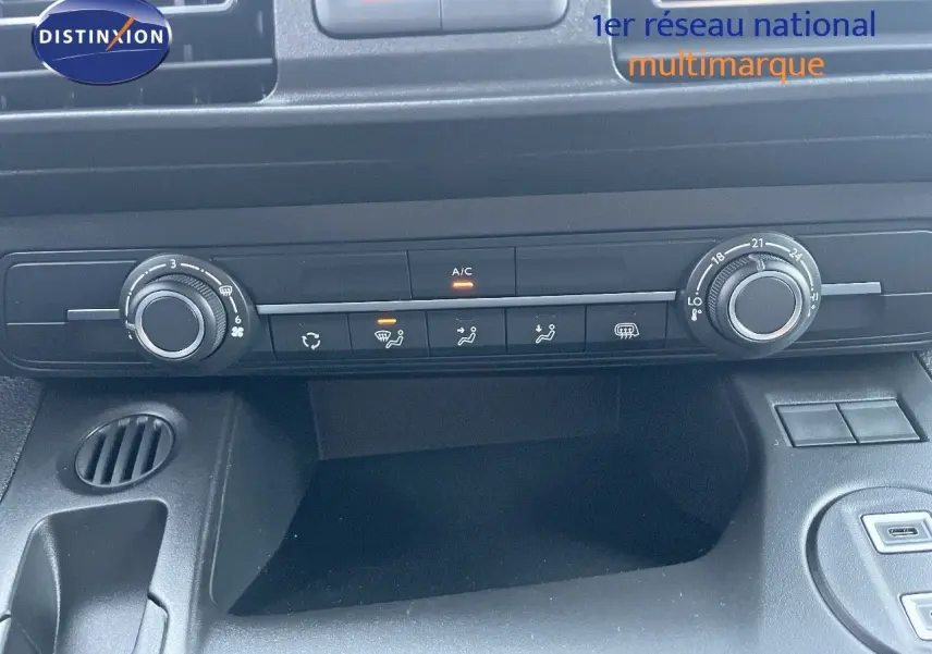 Vue rapprochée du tableau de bord noir du Peugeot Partner 2025, montrant les commandes de climatisation et ventilation.