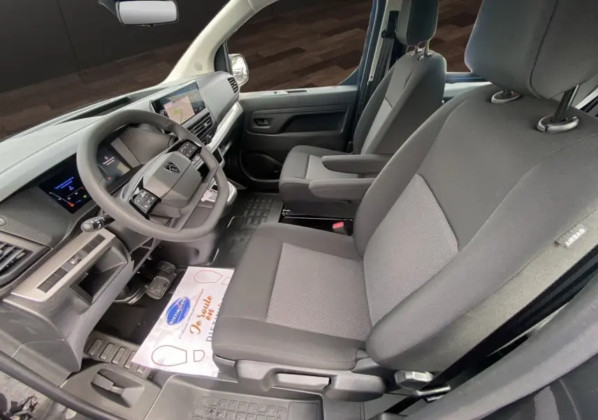 Vue intérieure côté conducteur du Peugeot Expert Cabine Approfondie 2025, sièges tissu noir et tableau de bord moderne.