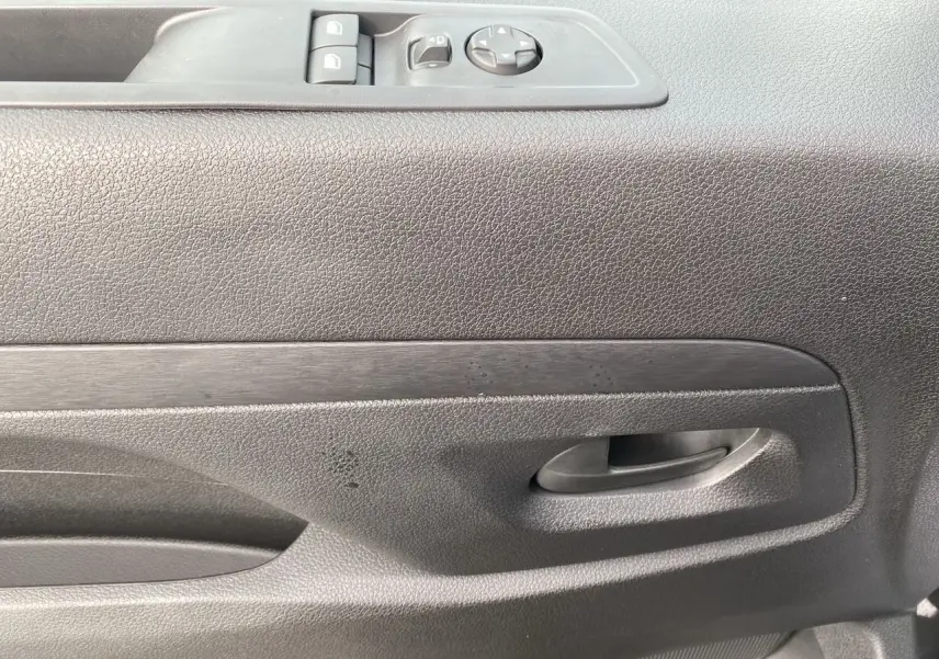 Détail de la porte intérieure côté conducteur du Peugeot Expert gris titane avec commandes électriques des vitres.
