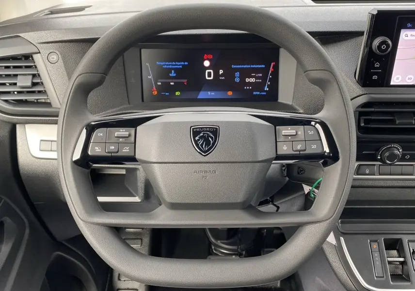 Vue rapprochée du volant noir du Peugeot Expert cabine approfondie 2025 avec tableau de bord numérique et écran tactile.