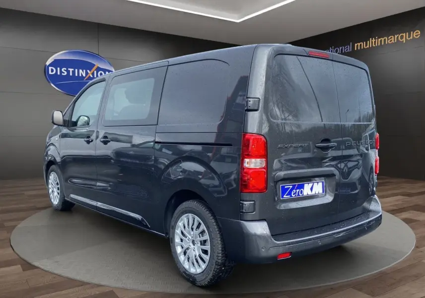 Vue 3/4 arrière droite d’un Peugeot Expert Cabine Approfondie gris titane avec jantes argentées et vitres latérales teintées.