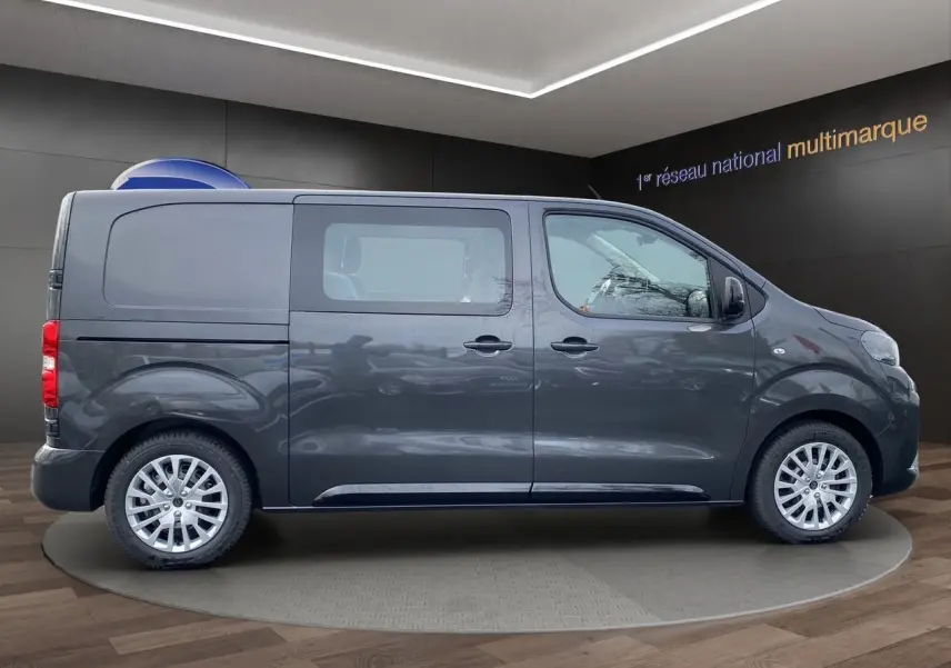 Vue de profil côté gauche d'un Peugeot Expert Cabine Approfondie gris titane avec jantes alliage et vitres teintées.