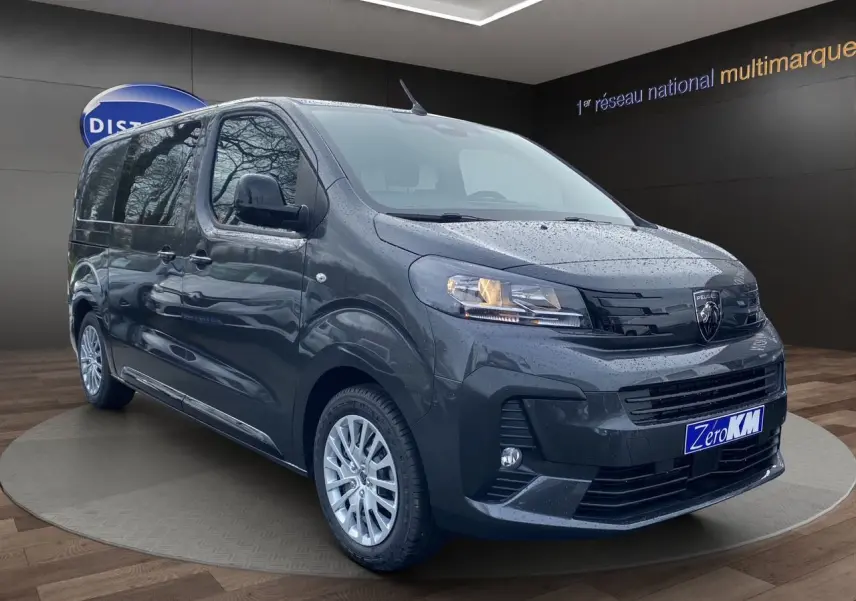 Vue 3/4 avant droit du Peugeot Expert Cabine Approfondie gris titane avec jantes argentées et projecteurs allumés.
