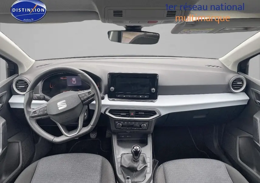 Vue intérieure avant de la SEAT Ibiza 1.0 TSI 95 Copa 2025, volant cuir méplat, tableau de bord noir et gris, boîte manuelle.