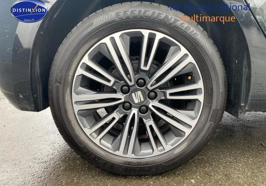 Gros plan sur la jante alliage 16 pouces de la SEAT Ibiza noir minuit, roue avant droite visible sur sol humide.