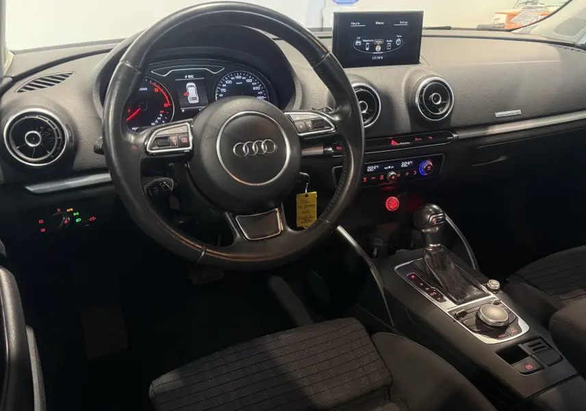 Intérieur Audi A3 Sportback 2015 vue côté conducteur, volant cuir, tableau de bord digital et console centrale avec boîte auto.