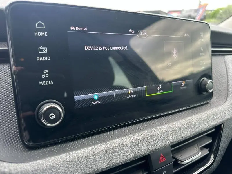 Gros plan sur l'écran tactile multimédia du tableau de bord de la Skoda Scala blanc cristal, affichant un message Bluetooth.