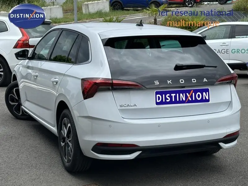 Vue 3/4 arrière droite d'une Skoda Scala blanc cristal avec feux arrière LED et jantes alu noires.