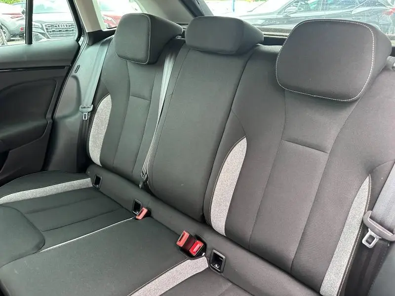 Vue intérieure de la banquette arrière noire et grise du Skoda Scala 2025, avec ceintures de sécurité visibles.