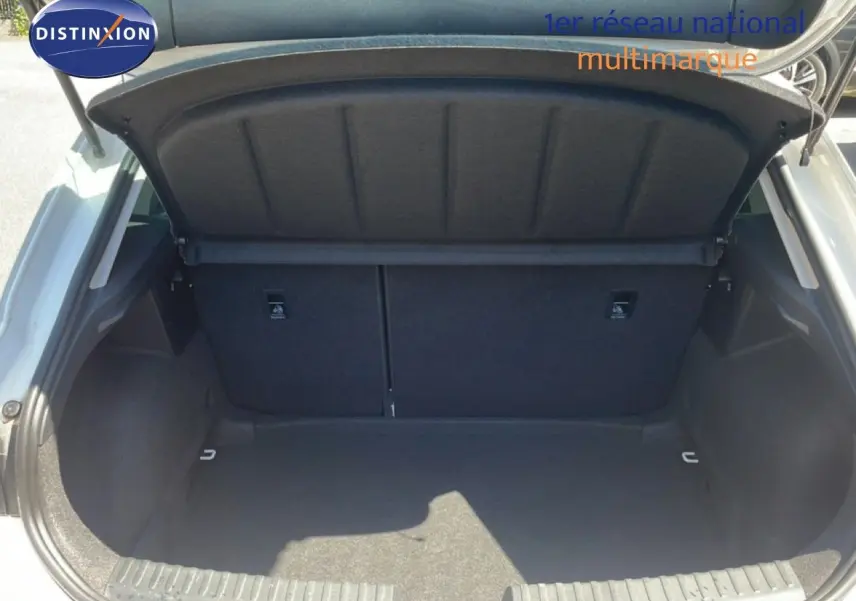Coffre ouvert vu de l'arrière d'une SEAT Leon blanche 2025, espace de chargement vide et propre.