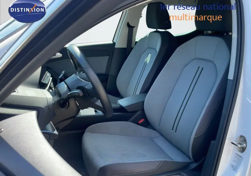 Vue intérieure côté conducteur du siège avant gris clair avec détails noirs d'une SEAT LEON blanche 2025.