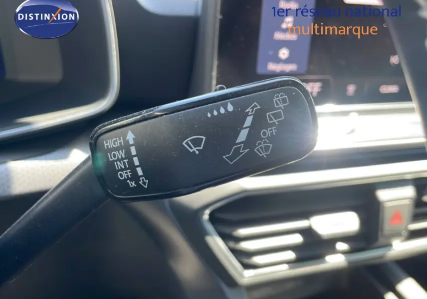 Gros plan sur la commande d’essuie-glace dans l’habitacle d’une SEAT LEON blanche, tableau de bord en arrière-plan flou.