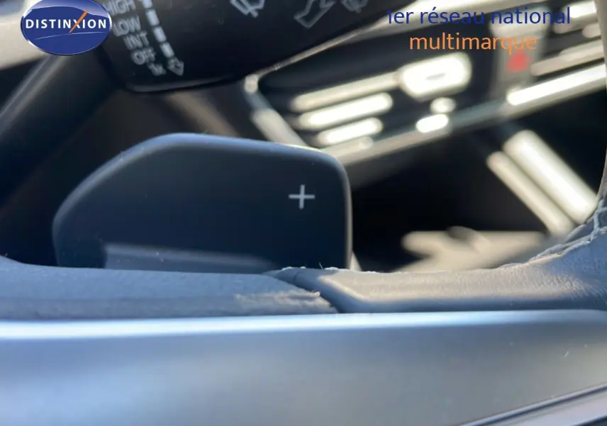 Gros plan sur la palette de changement de vitesse droite du volant d’une SEAT LEON blanche, intérieur gris-noir.