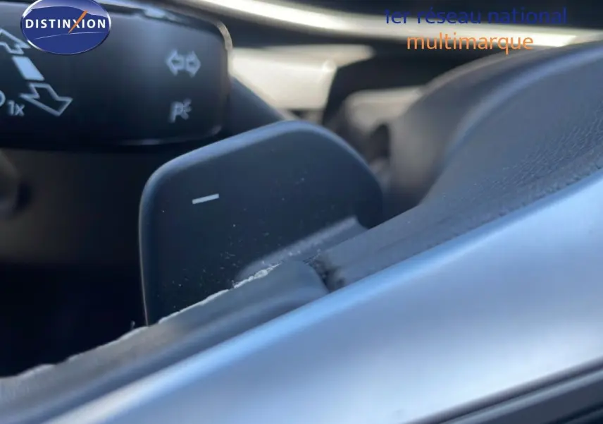 Gros plan sur la palette de changement de vitesse côté droit du volant d’une SEAT LEON blanche, version 2025.