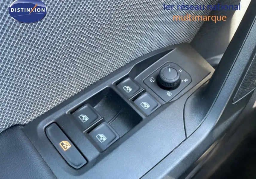 Gros plan sur les commandes de lève-vitres et rétroviseurs côté conducteur d'une SEAT LEON blanche 2025.