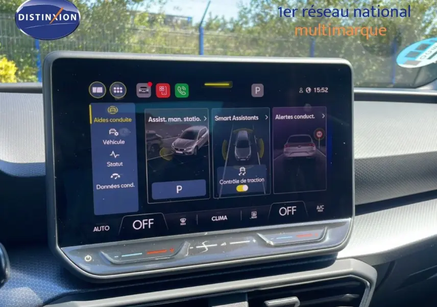 Vue intérieure du tableau de bord de la SEAT LEON blanc 2025, avec écran tactile central affichant les aides à la conduite.