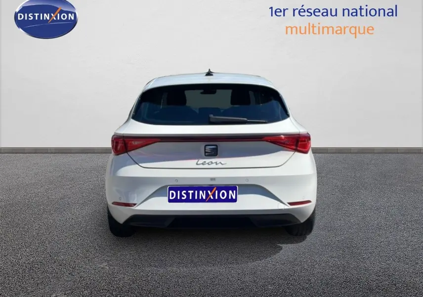 Vue arrière d'une SEAT Leon blanche 2025 avec feux arrière reliés et logo central distinctif.