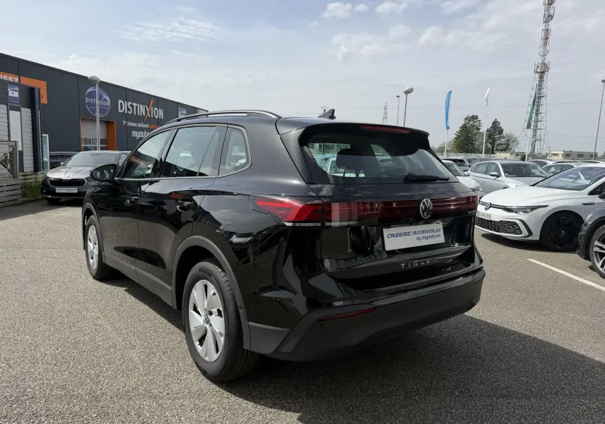 Vue 3/4 arrière droite d'un Volkswagen Tiguan noir 2025 avec feux arrière LED et jantes alliage 17 pouces.