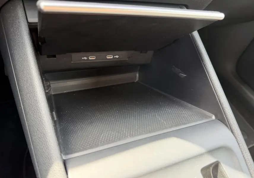 Rangement intérieur ouvert avec ports USB-C visibles, console centrale noire du Volkswagen Tiguan 2025.