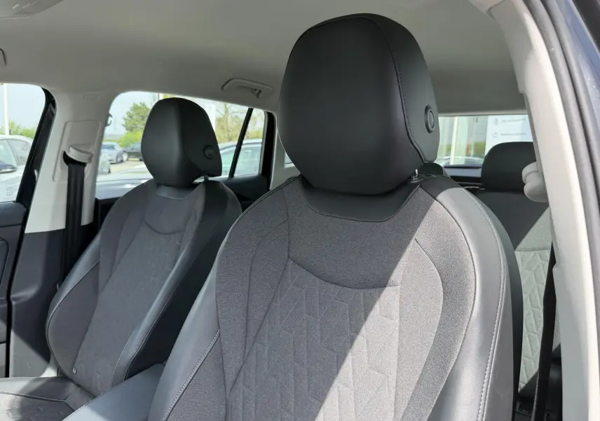 Gros plan sur les sièges avant gris et noir du Volkswagen Tiguan 2025, vue intérieure côté passager.
