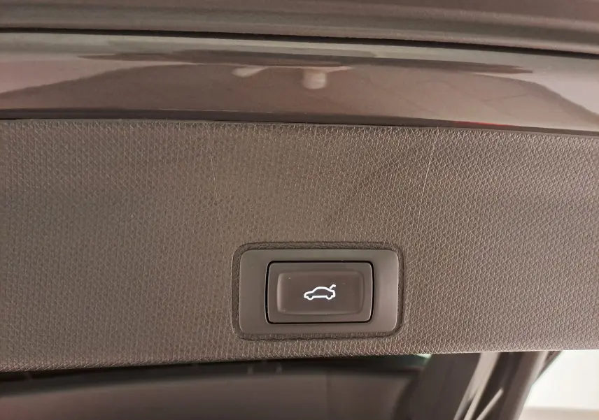 Bouton d'ouverture électrique du coffre sur la garniture intérieure du hayon d'un CUPRA TERRAMAR gris Timanfaya.
