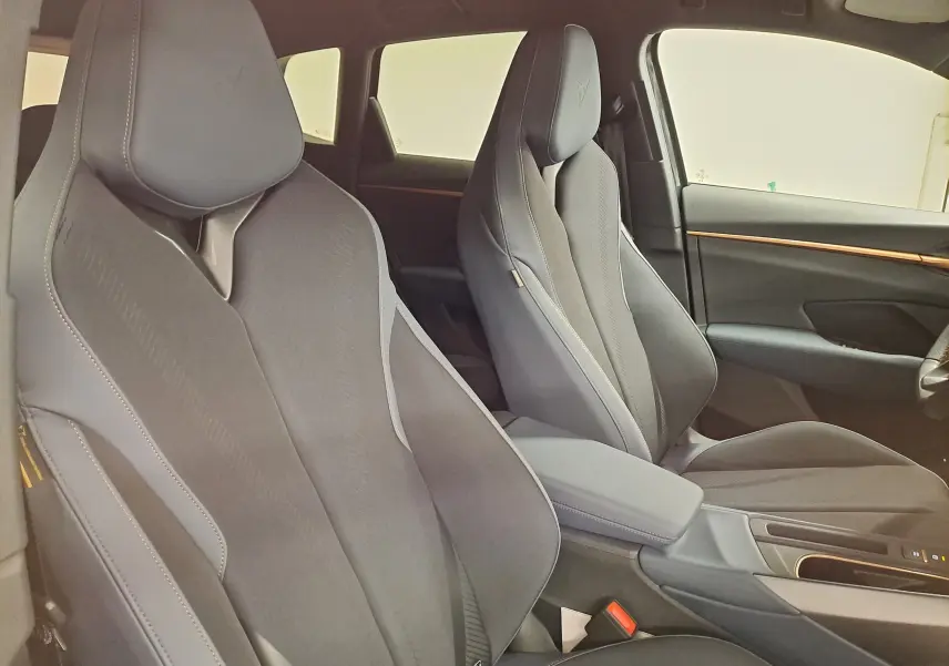 Vue intérieure des sièges avant en tissu et cuir noir avec surpiqûres contrastées dans une CUPRA TERRAMAR 2025.
