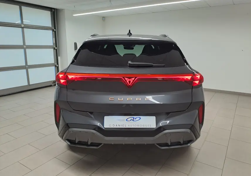 Vue arrière d'un CUPRA TERRAMAR gris Timanfaya avec feux LED en bandeau et logo lumineux au centre.