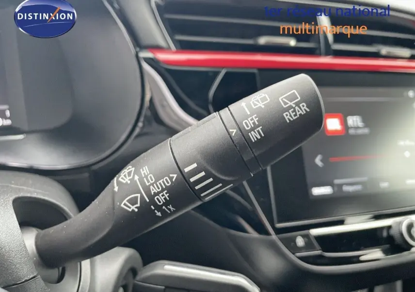 Gros plan sur la commande d'essuie-glace à gauche du volant dans l'habitacle noir et rouge d'une Opel Corsa blanche 2022.